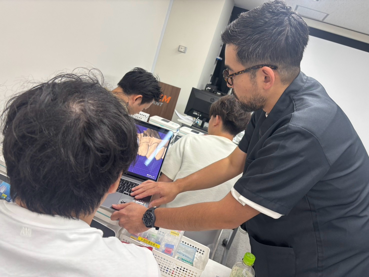 OSSTEM JAPAN MASTER COURSEの実習で受講者へ個別指導を行う橋口隼人