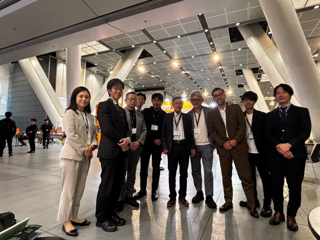 東京国際フォーラムの学会展示会場で小林文夫先生をはじめ参加者と撮影した集合写真