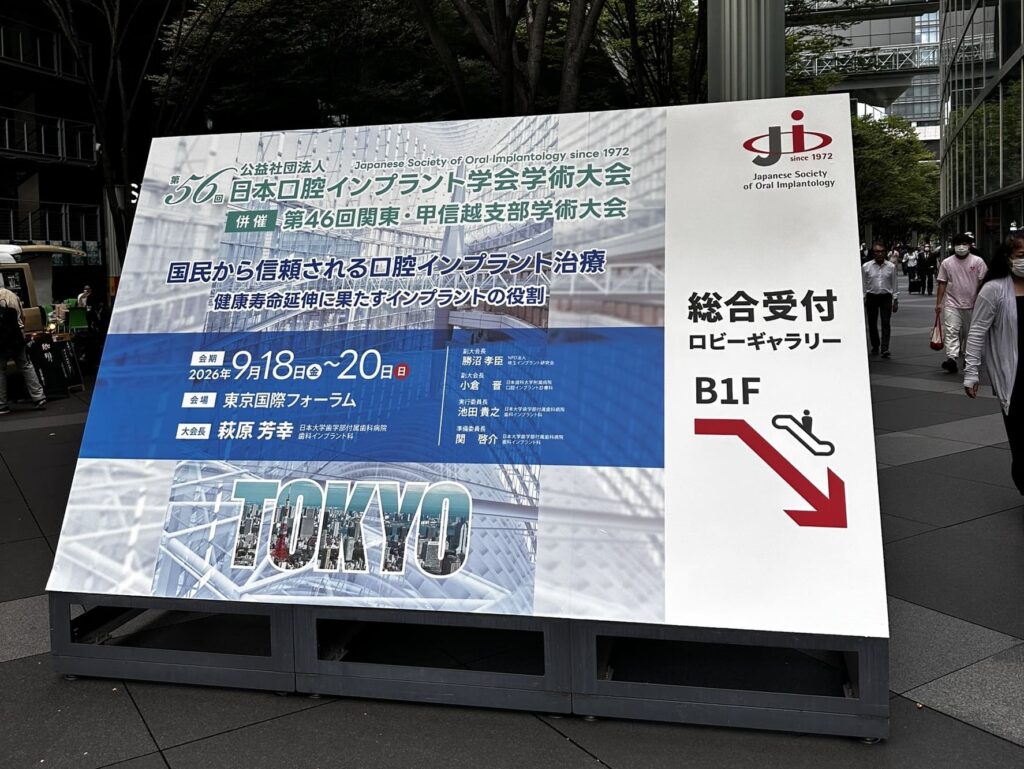 東京国際フォーラムに設置された第56回日本口腔インプラント学会学術大会の大会名・テーマ・会期を記した案内看板